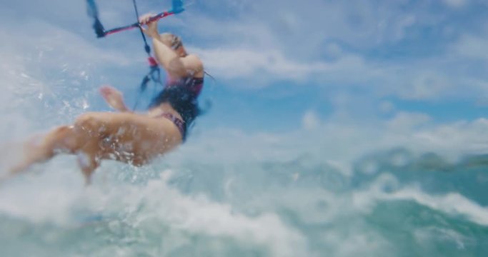 Beautiful young woman kiteboarding in slow motion, active lifestyle extreme sport