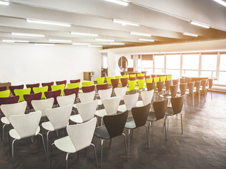 Rows of chairs locating in bright spacious room. Interior concept
