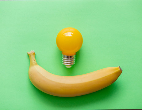 Yellow banana with bulb on green background. Natural light