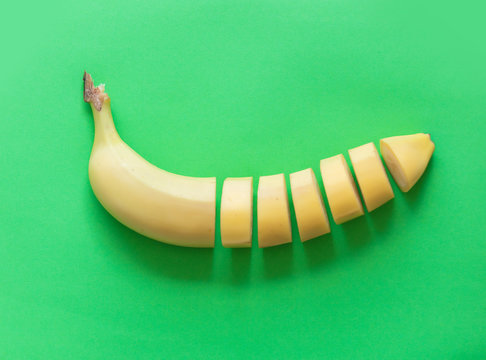Yellow cut banana isolated on green background. Natural light