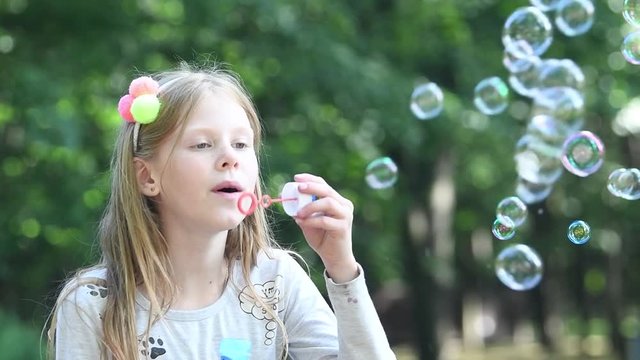 summer fun. Girl with soap bubble. slow motion
