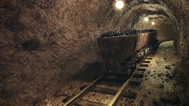 Coal mine carts or wagons slowly moving through narrow underground tunnel.