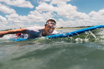 man is swimming on surfboard in the ocean