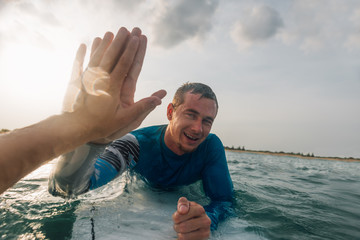 from   first person, give five surfers on the water