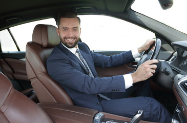 portrait of confident businessman driving a car