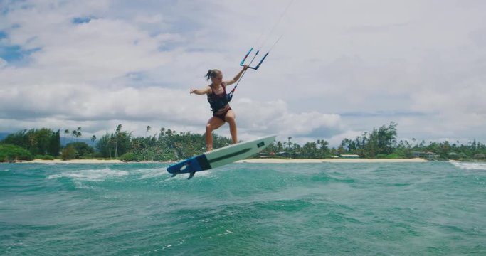 Beautiful young woman kitesurfing in slow motion