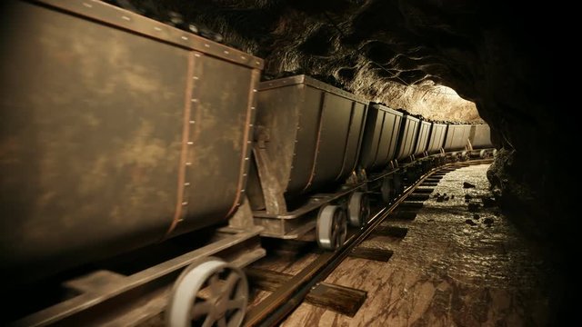 Coal mine carts or wagons slowly moving through narrow underground tunnel.