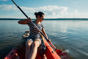   girl sails on a kayak, paddles with a paddle.