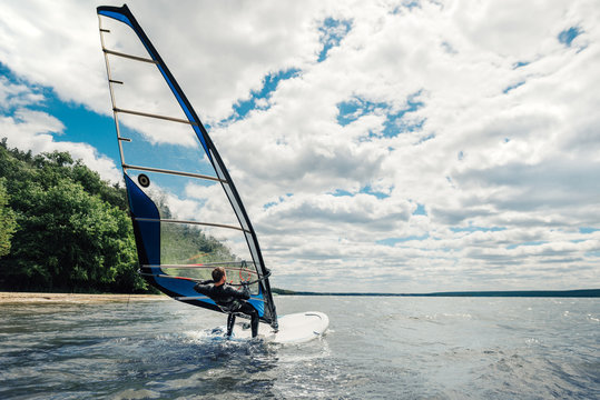 the guy in the waggon swims on the windsurf on   lake