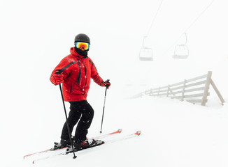 Fototapeta na wymiar skier stands near the fence under chair lift