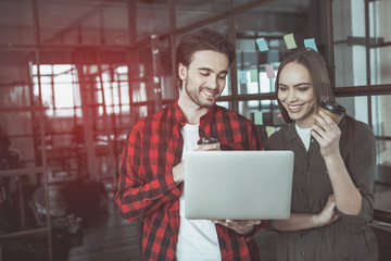 Full of joy. Portrait of happy attractive girl is standing with her friendly colleague with modern...