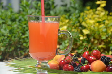 extremely close up glass of tasty tropical alcohol cocktail with berries or lemonade with beautiful decoration on a table in a restaurant with backgrounds of bright colored lights. soft focus.