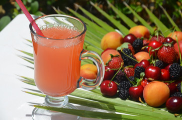 extremely close up glass of tasty tropical alcohol cocktail with berries or lemonade with beautiful decoration on a table in a restaurant with backgrounds of bright colored lights. soft focus.