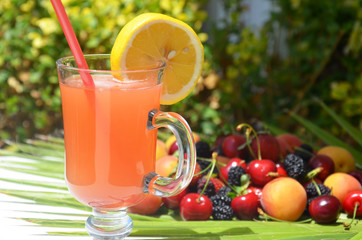 extremely close up glass of tasty tropical alcohol cocktail with berries or lemonade with beautiful decoration on a table in a restaurant with backgrounds of bright colored lights. soft focus.