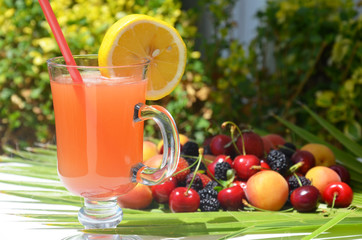extremely close up glass of tasty tropical alcohol cocktail with berries or lemonade with beautiful decoration on a table in a restaurant with backgrounds of bright colored lights. soft focus.