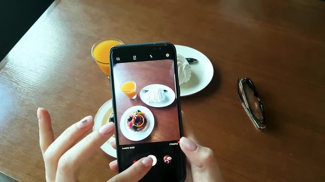 Take a photo of food in a restaurant with mobile phone camera for social network