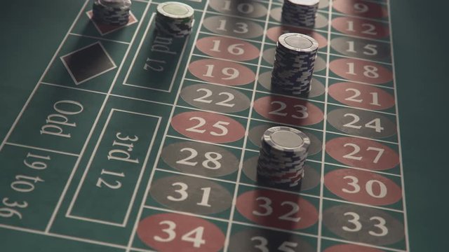 Roulette table with casino chips or tokens stacking on a bet. Timelapse.