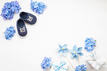 Cute newborn baby boy shoes with festive decoration. Baby shower, birthday, invitation or greeting...