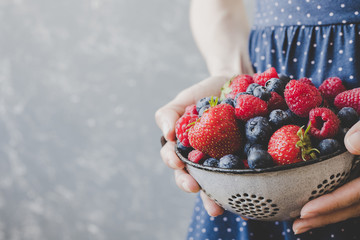 Hands holding fresh juicy berries. Summer background with copy space - obrazy, fototapety, plakaty