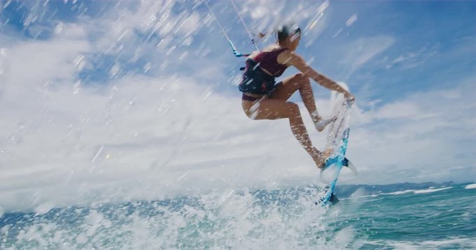 Beautiful young woman surfing, extreme sport slow motion