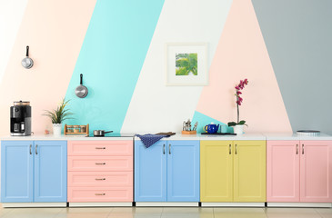 Modern kitchen furniture on color wall background