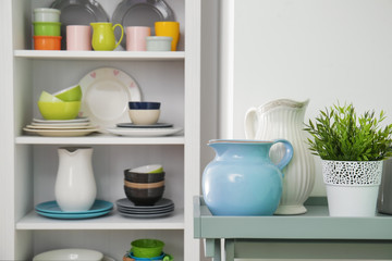 White storage stand with colorful ceramic dishware indoors