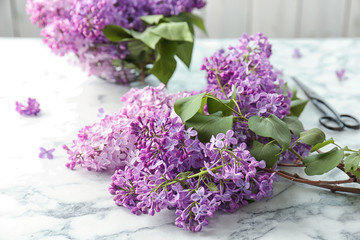 Beautiful blossoming lilac and scissors on table. Spring flowers