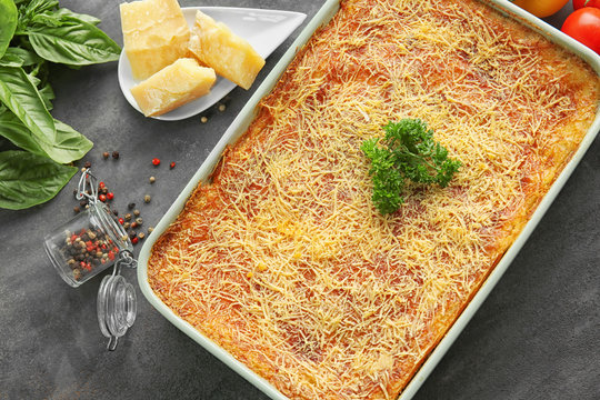 Baking tray with tasty spinach lasagna on table