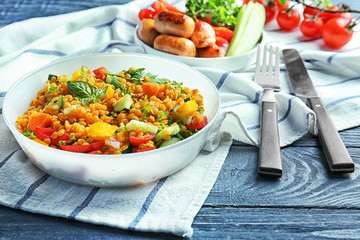 Bowl with delicious lentils salad on wooden table