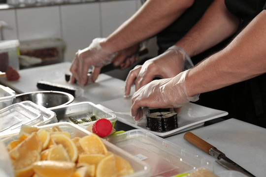 Chef making tasty maki rolls in restaurant