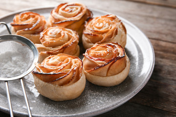 Plate with apple roses from puff pastry on table, closeup
