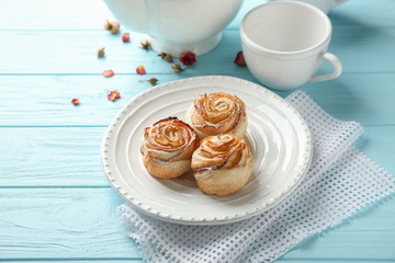 Plate with apple roses from puff pastry on color wooden table