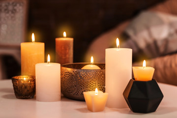 Fototapeta na wymiar Burning candles on table indoors