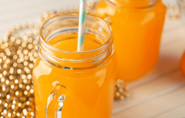 Mason jar with fresh citrus juice on table, closeup