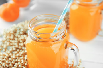 Mason jar with fresh citrus juice on table, closeup