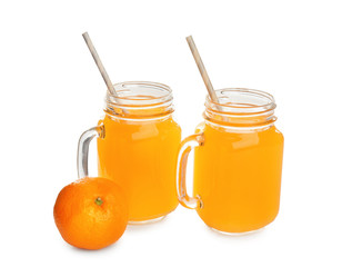 Mason jars with fresh citrus juice and tangerine on white background