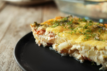 Plate with tasty broccoli casserole on table. Fresh from oven