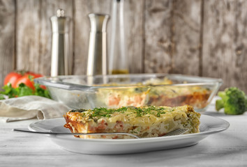 Plate with tasty broccoli casserole on table. Fresh from oven