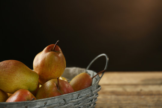 Basket with delicious pears on blurred background
