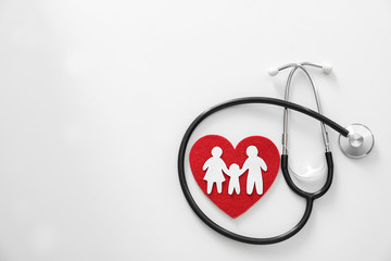 Paper silhouette of people, red heart and stethoscope on light background, top view