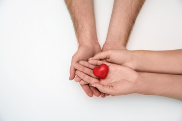 Young couple with red heart on white background, top view