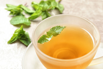 Cup with hot aromatic mint tea, closeup