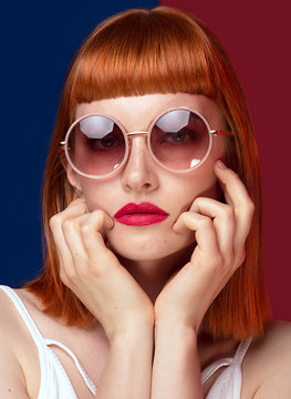 Beautiful redhead girl in sunglasses .