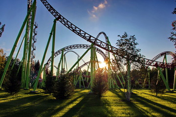 Fototapeta na wymiar Sunset in the amusement park. Roller coaster.