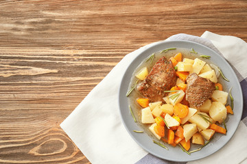 Plate with tasty meat and potatoes on table