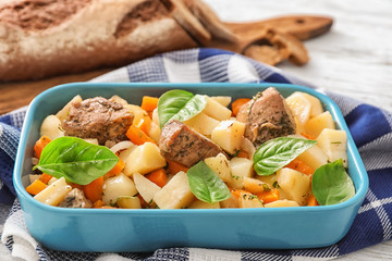 Casserole with tasty meat and potatoes on table