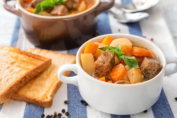 Casserole with tasty meat and potatoes on table