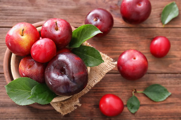 Ripe juicy plums on wooden table