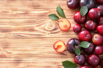 Ripe juicy plums on wooden table