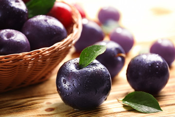 Ripe juicy plums on table